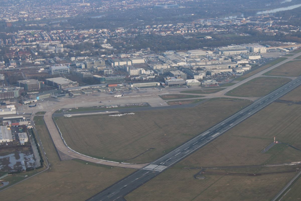 Blick aus dem Flugzeug nach unten. Dort ist der internationale Verkehrsflughafen Bremen zu sehen. Wir fliegen in ca. 1500 Fuß und sehen die Landebahn, das Flughafengebäude und ganz klein eine rollende Lufthansa Boing 737, die zur Startbahn 09 (also nach osten) starten will. Danke an das Team im Tower Bremen. 